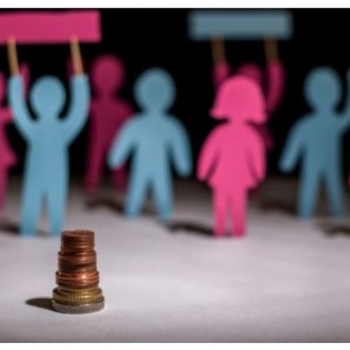 Silhouettes en papier bleu et rose en arrière plan et pile de pièces au premier plan